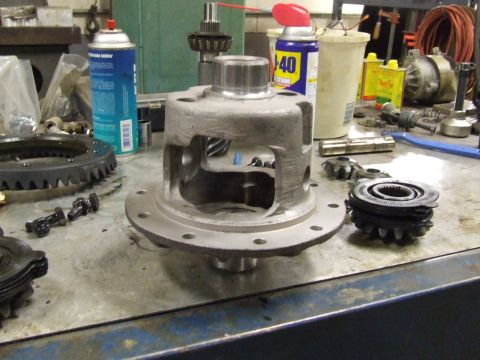 1967 Ford Bronco - Close-up of a differential carrier and associated gears, surrounded by automotive maintenance supplies.