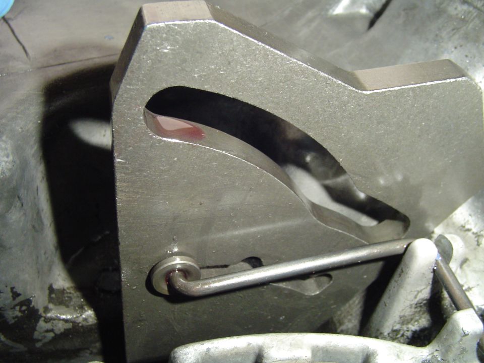 Close-up of slotted steel tool fixture with a hooked rod