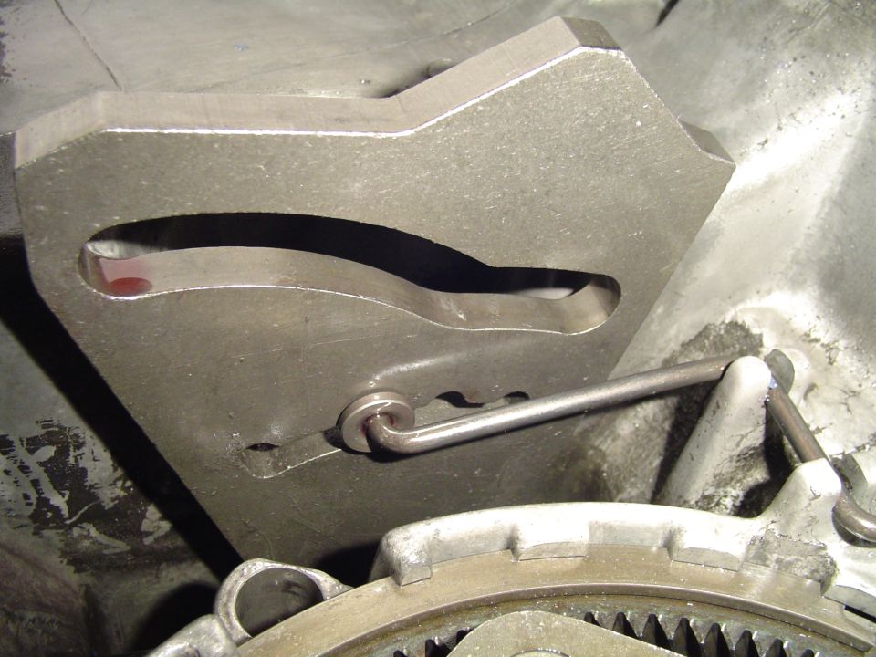 Slotted steel tool fixture with hooked rod under a vehicle