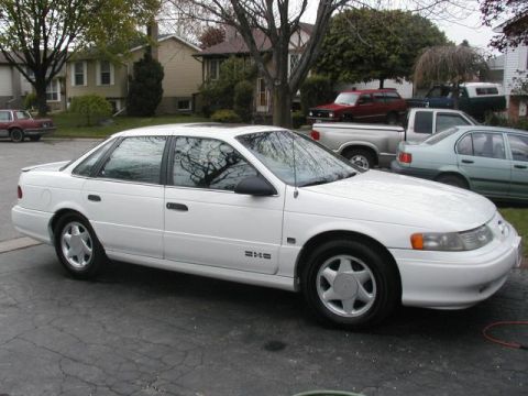 1993 Ford Taurus - This white 1993 Ford Taurus sedan is seen from a three-quarter front view, parked in a residential driveway.