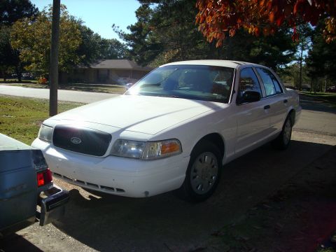2001 Ford Crown Victoria - A white 2001 Ford Crown Victoria is parked on a driveway under a tree with autumn leaves.