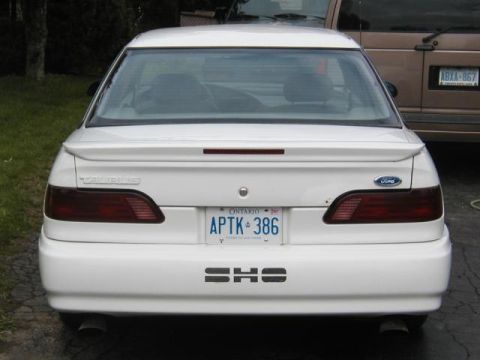 1993 Ford Taurus - 1993 Ford Taurus SHO seen from the rear, parked next to another vehicle.