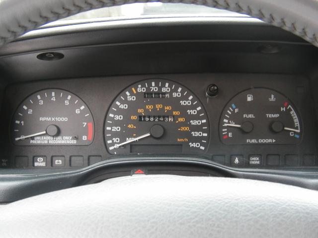 Ford gauge cluster: 8k tachometer, 140 mph speedometer showing 158,243 miles, fuel and temp gauges