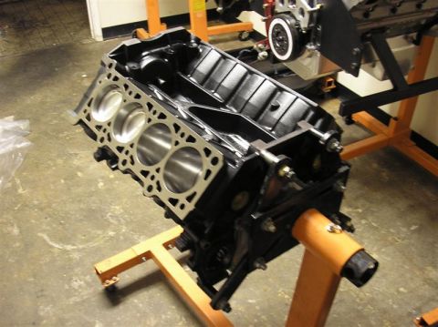 2007 Ford Mustang - A black engine block is mounted on an orange engine stand, ready for assembly or inspection.