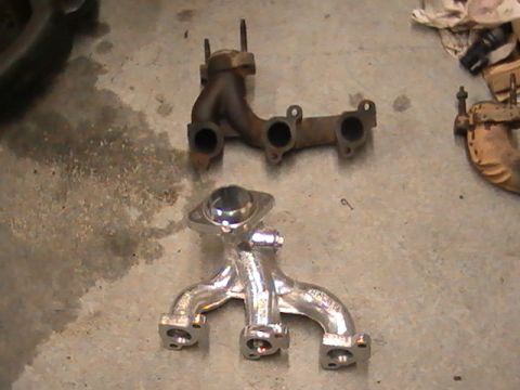 1990 Ford Probe - A comparison of a rusty exhaust manifold and a newly polished one sits on a garage floor.