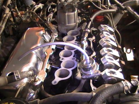 1990 Ford Probe - Close-up view of an engine bay, a chrome intake manifold and distributor cap.