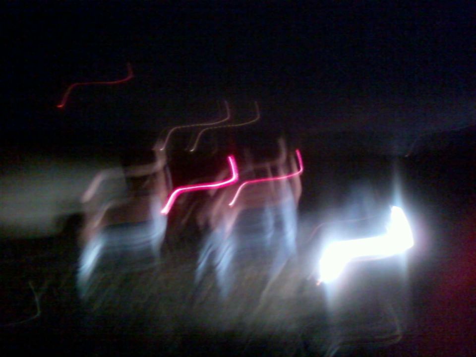 Blurry streaks of pink and white light against a dark background