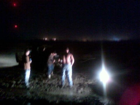 1996 Dodge 1500 - Several individuals are gathered in a dark, outdoor area at night, illuminated by a strong light.