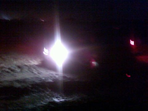 1996 Dodge 1500 - Headlights and taillights are visible in this nighttime photo, with a bright light source in the center.