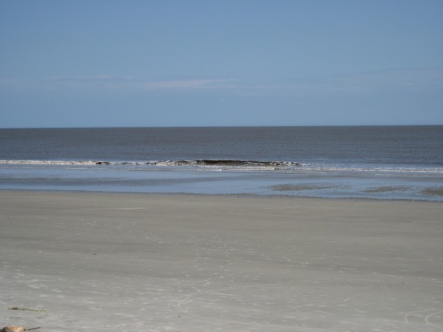 Beach with calm ocean and clear blue sky