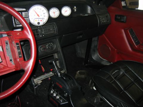 1992 Ford Mustang - Interior view of a car, a red steering wheel and custom gauges.
