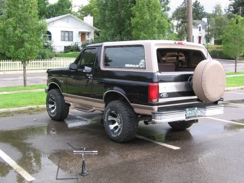 1996 Ford Bronco - This black and tan Ford Bronco features a two-tone paint scheme and a spare tire mounted on the rear.