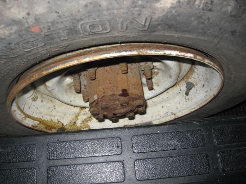 1988 Ford Bronco - Close-up view of a heavily rusted wheel hub assembly and tire tread.
