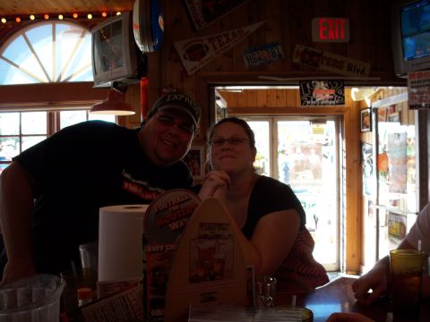 1996 Ford Bronco - A couple poses for a photo at a Hooters restaurant, surrounded by sports pennants and memorabilia.