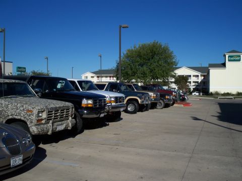1996 Ford Bronco - Several Ford Broncos are parked in a lot on a sunny day.