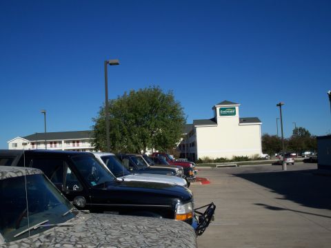 1996 Ford Bronco - The front end of a 1996 Ford Bronco is visible in a parking lot, alongside other vehicles.