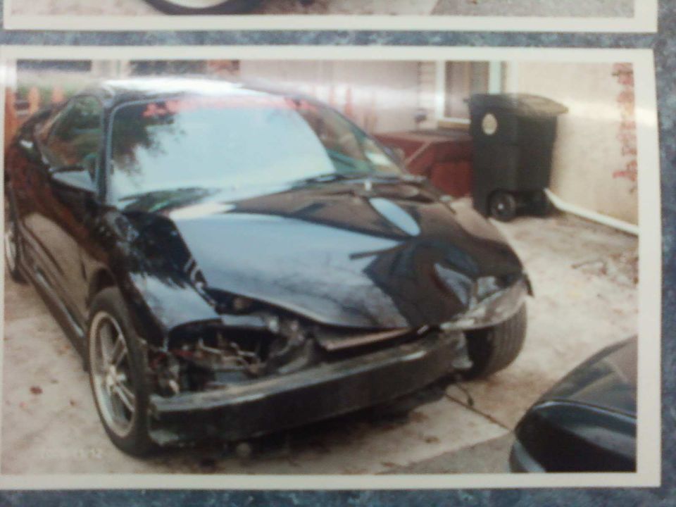 Black coupe with damaged front end and missing bumper