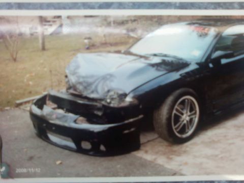 1996 Dodge 1500 - Car with damaged front end, bumper removed and hood covered with a tarp.