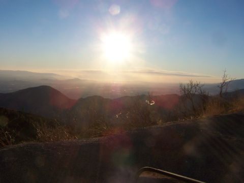 1990 Ford Bronco - Sunrise over mountains and valley with a hazy sky.