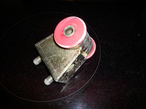 1993 Ford Probe - A red polyurethane bushing is mounted on a metal bracket, likely a suspension or engine component.