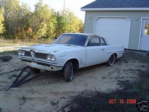 1970 Ford Ranchero - A white 1962 Pontiac Tempest sits on a dirt lot next to a garage.