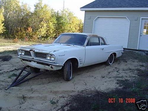 1962 Pontiac Tempest parked in front of a garage