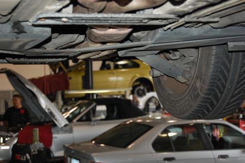 2002 BMW M3 - The undercarriage of a 2002 BMW M3 is visible, with other vehicles in the background.