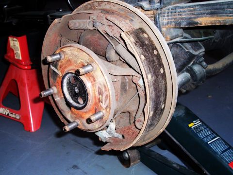 1978 Ford Bronco - Close-up of a rusty rear drum brake assembly, likely undergoing maintenance or repair.