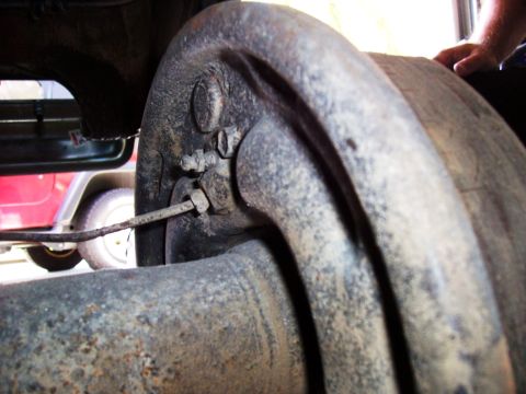 1978 Ford Bronco - A close-up view of the rear axle and brake drum assembly, with another vehicle partially visible in the background.