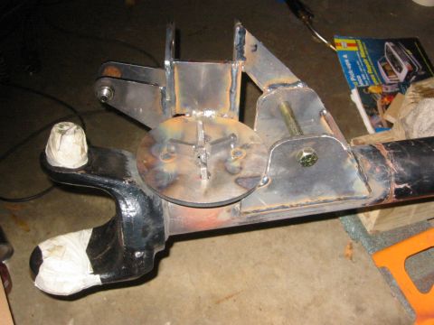 1995 Ford Bronco - Close-up of a custom-fabricated suspension part, possibly for an off-road vehicle, with visible welding and hardware.