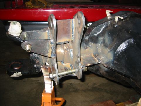 1995 Ford Bronco - Close-up of a custom suspension component attached to a vehicle's differential, resting on a jack.