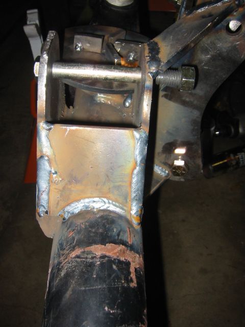 1995 Ford Bronco - Close-up view of a custom-welded metal bracket and suspension component, with visible bolts and welds.