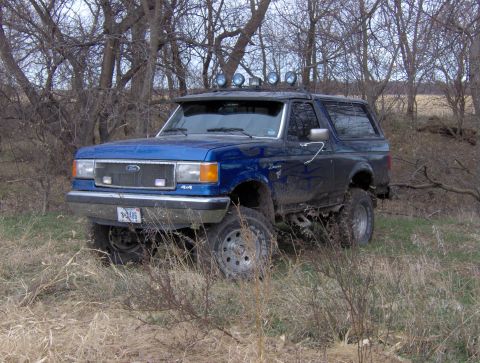 1987 Ford Bronco - This 1987 Ford Bronco is equipped with off-road lights and appears to be in a natural, unpaved setting.