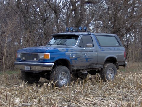1987 Ford Bronco - This 1987 Ford Bronco is shown in a field with trees in the background.