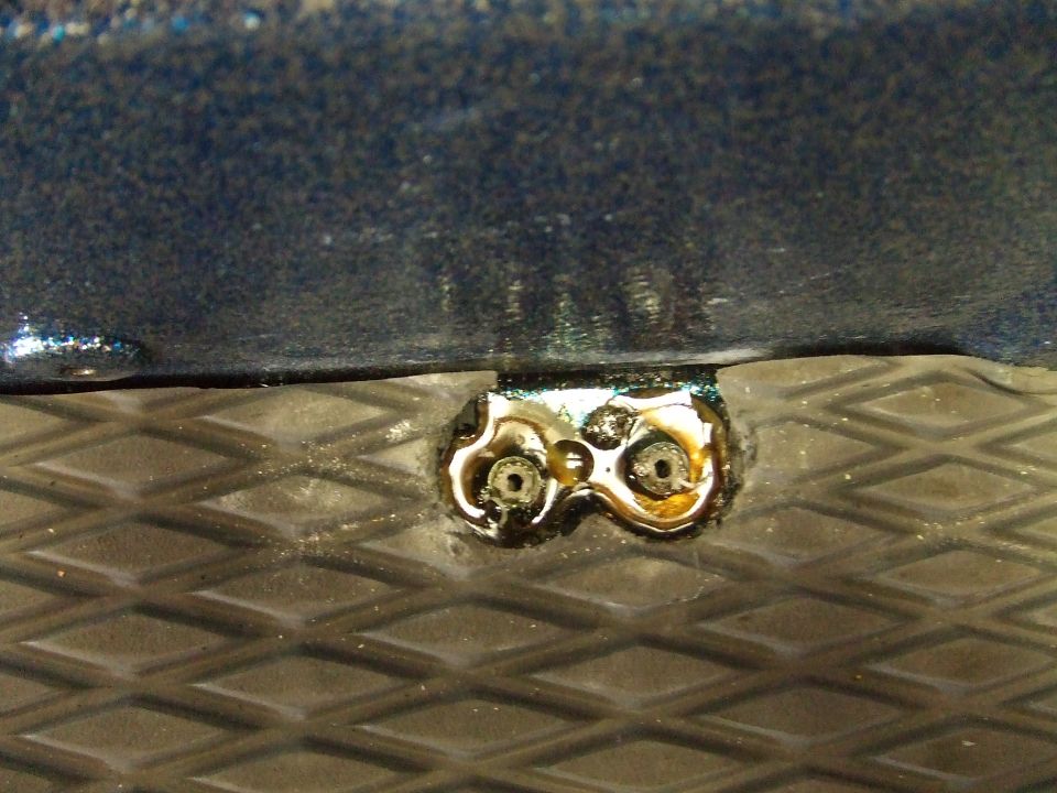 Blue hull detail with metal bracket and bolts on textured surface