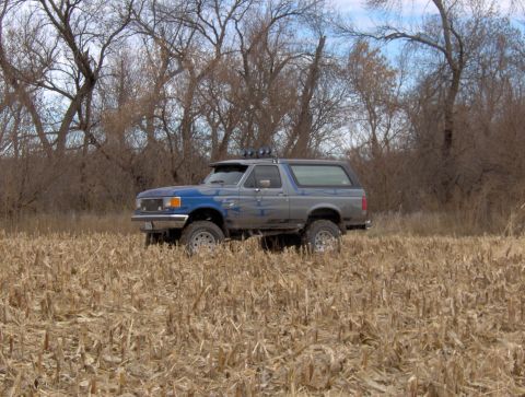 1987 Ford Bronco - This 1987 Ford Bronco is parked in a field of harvested corn under a cloudy sky.