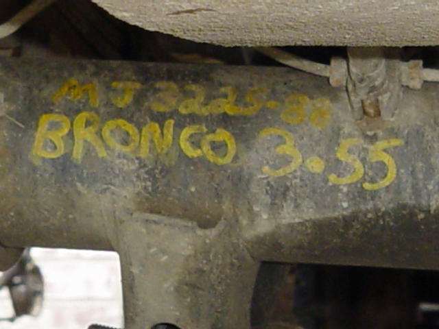 Grimy axle housing marked in yellow paint: MJ3225-88, BRONCO, 3.55 gear ratio