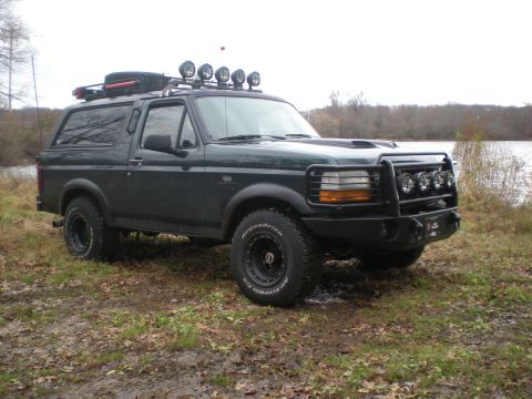 1993 Ford Bronco - 1993 Ford Bronco modified for off-road use, seen parked near a body of water.