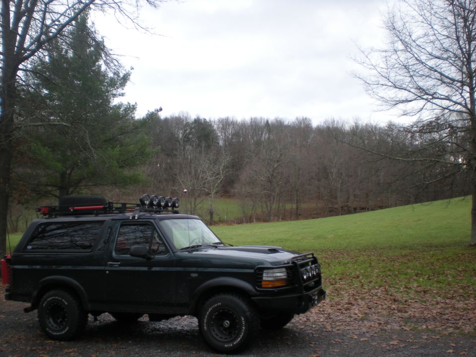 1993 Ford Bronco with roof rack and auxiliary lights parked outdoors.