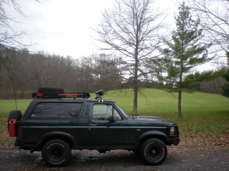 1993 Ford Bronco parked outdoors with roof rack and rear-mounted spare tire and gas can.