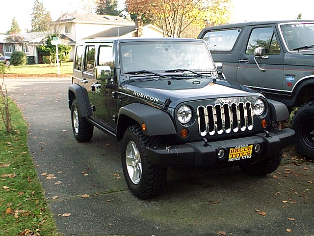 Charcoal Jeep Wrangler Unlimited Rubicon parked in driveway, front 3/4 view