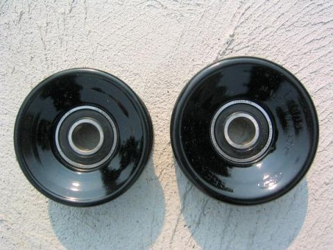2007 Ford Mustang - Photograph of two black serpentine-belt idler pulleys, not a technical document.