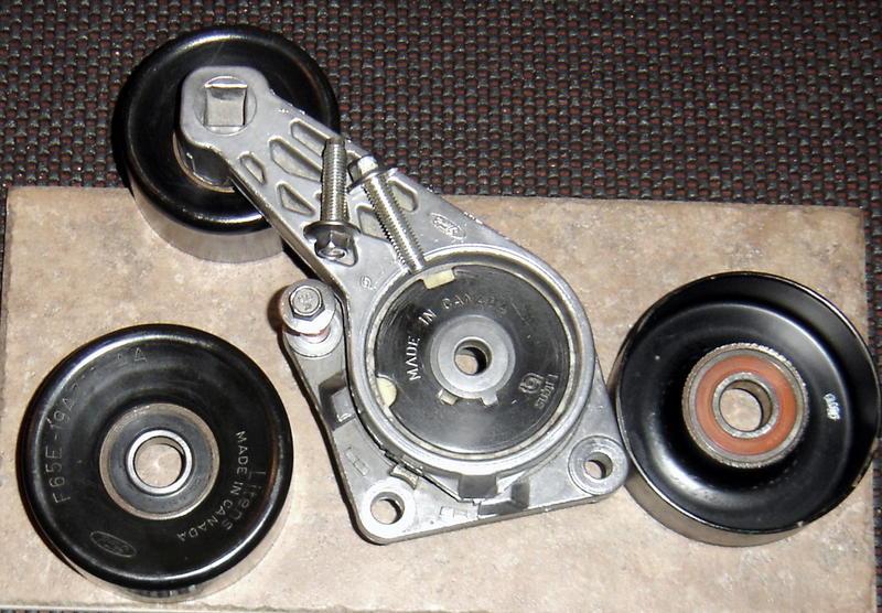 Serpentine belt tensioner assembly and two idler pulleys