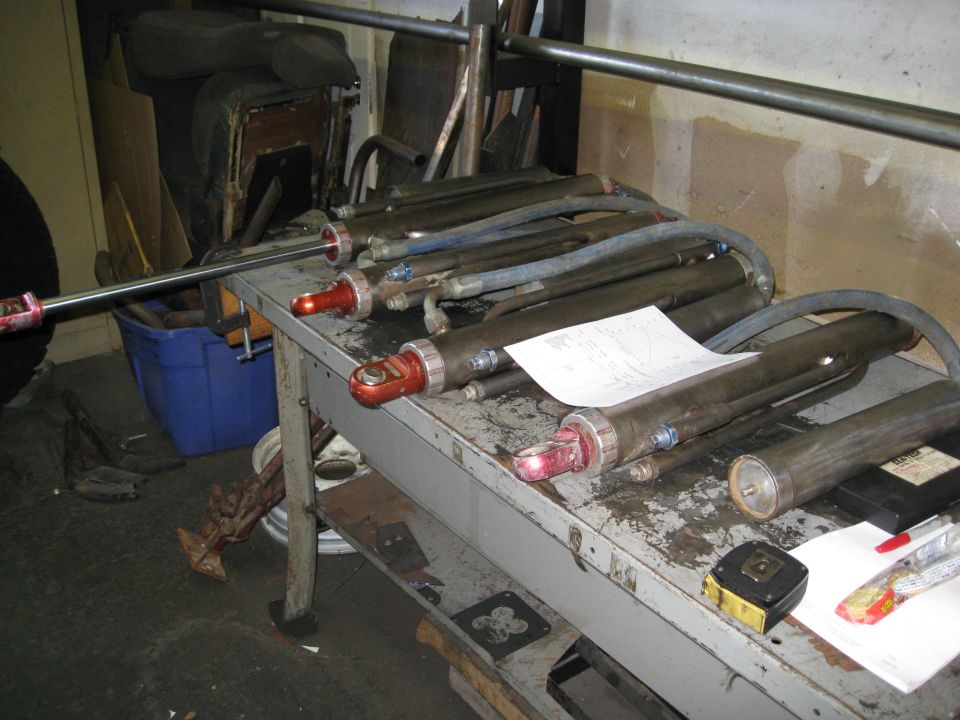 Hydraulic cylinders on a workbench with a graph.