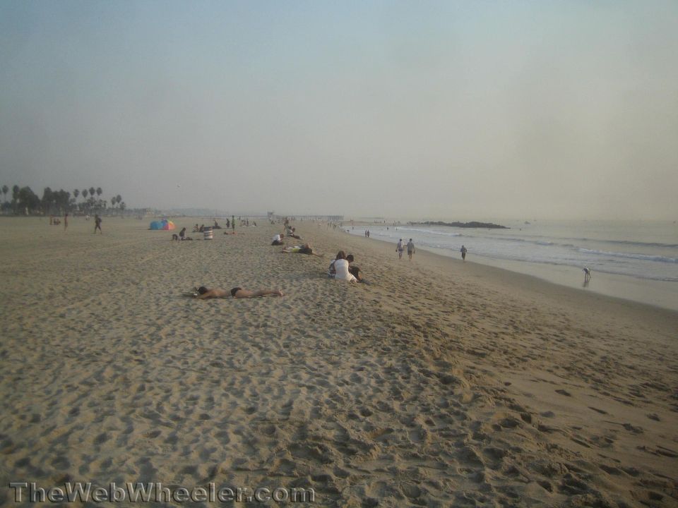 Beach scene with people sunbathing and walking along the shore