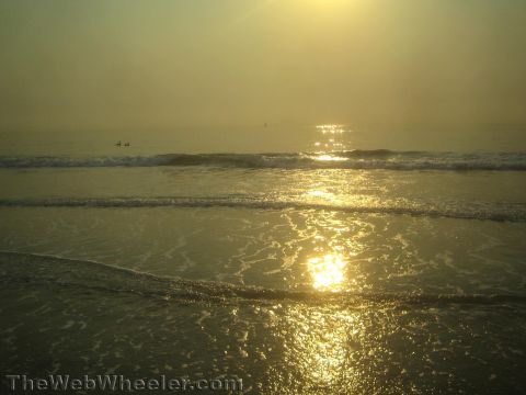 1968 Ford Mustang - A beach scene captures the golden hues of a sunset over the ocean waves.