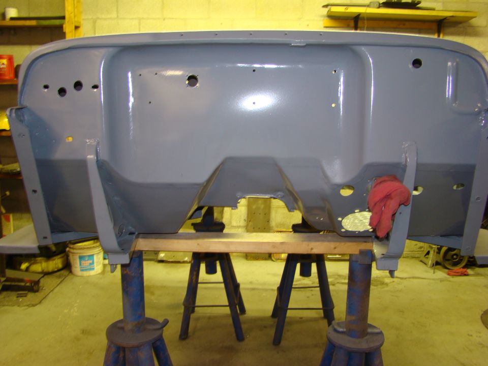Gray Jeep firewall on jack stands with a red rag.