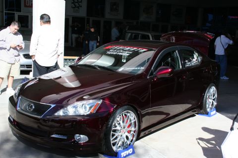 1998 Ford Crown Victoria - Photograph of a maroon Lexus IS show car parked on display ramps, not a document.