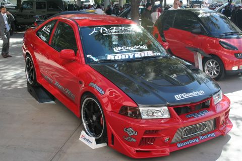 1998 Ford Crown Victoria - Photograph of a red widebody Mitsubishi show car with sponsor decals, not a technical document.