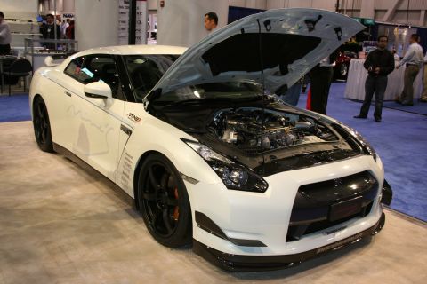 1998 Ford Crown Victoria - A white Nissan GT-R is displayed with its hood open, revealing the engine and intricate details.